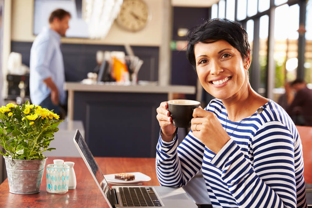 Woman enjoying a mug of coffee at a coffee house