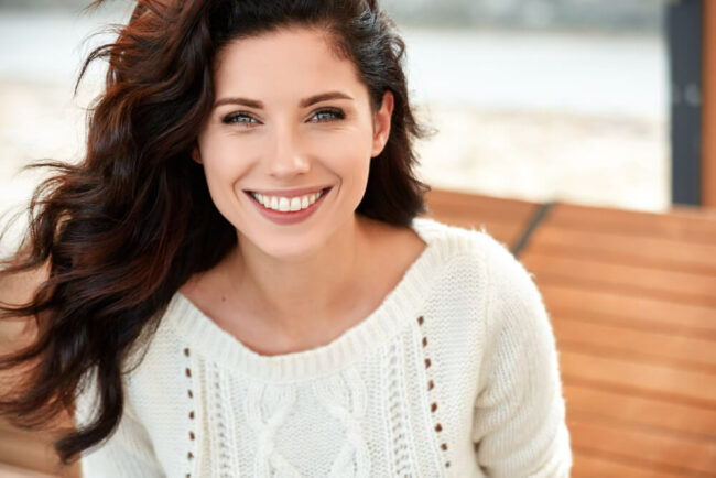 Happy, smiling woman in white sweater