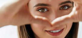 Girl looking through heart shaped hands