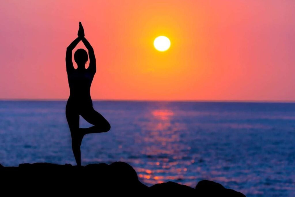 Girl with Glaucoma doing Yoga at the beach while the sun is setting