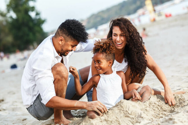 Young family playing on the beach